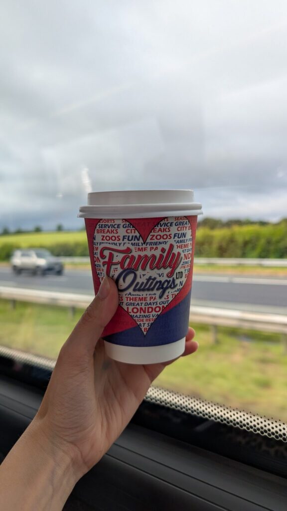 Holding up a travel cup on a coach.